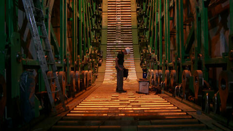 Stahlindustrie - Stranggießanlage. Ingenieur steht auf Rollenteppich.