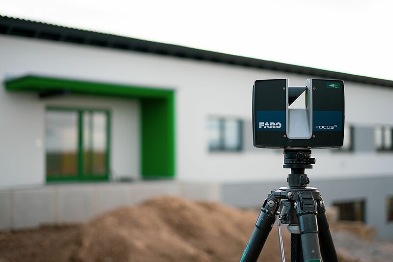 Der Laserscanner Faro Focus S steht vor einem Haus