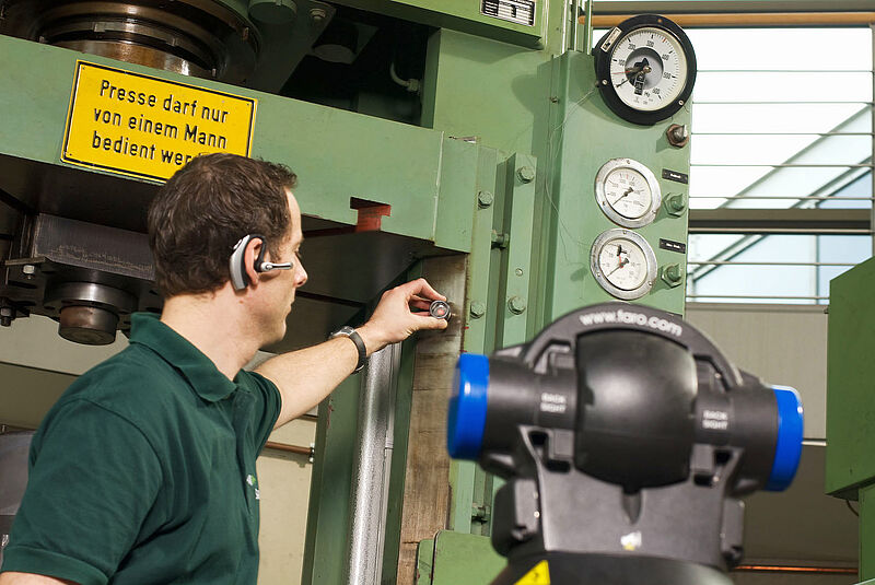 Ein Mann vermisst eine Presse mit einem Faro Lasertracker und einer Messkugel